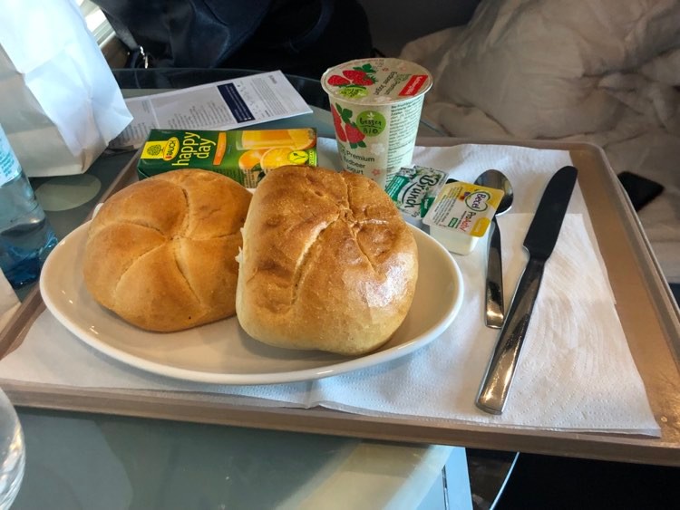 Sandwich, yoghurt and juice at table. Photo. 